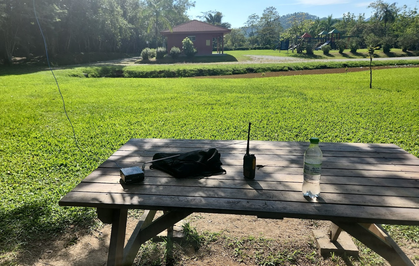 Field day setup on a picnic table at the Timbó, SC Botanical Garden, with the ATS-20+ and the wire antenna